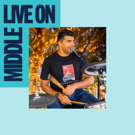 Live on Middle. Man playing drums and singing. 